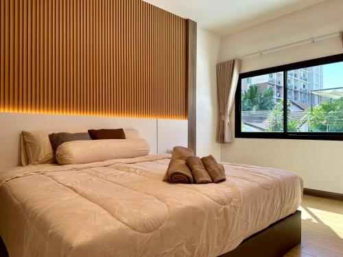a bedroom with a large bed and a large window at Apples Pattaya Townhouse in Pattaya South