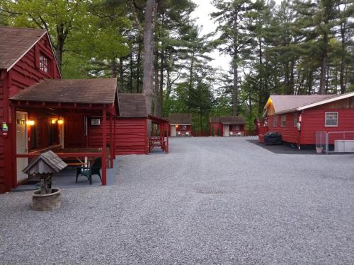 a group of red cabins in a parking lot at Do-Rest Court in Lake George