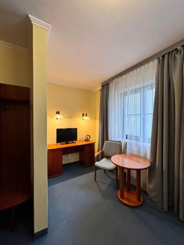 a hotel room with a table and a window at Pokoje Stary Rynek in Elblag