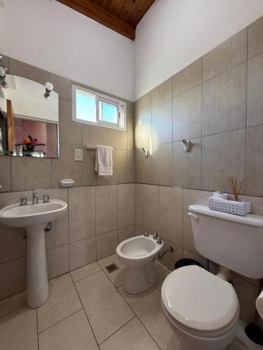 a bathroom with a toilet and a sink at AltoRojo in Villa Elisa