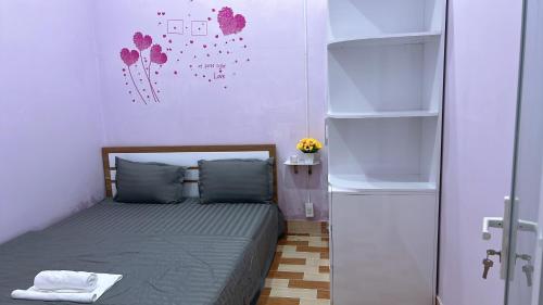 a small bedroom with a bed and a refrigerator at Ryo Homestay Dốc Lể in Ba Ha