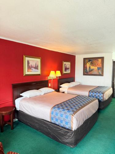 two beds in a hotel room with red walls at Gateway Inn in Sullivan