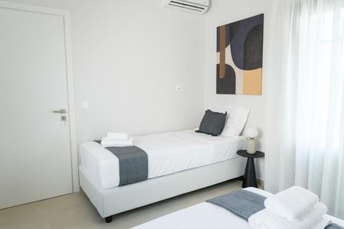a white bedroom with a bed and a window at Villa Selina 4 - Etheras Properties in Kythira