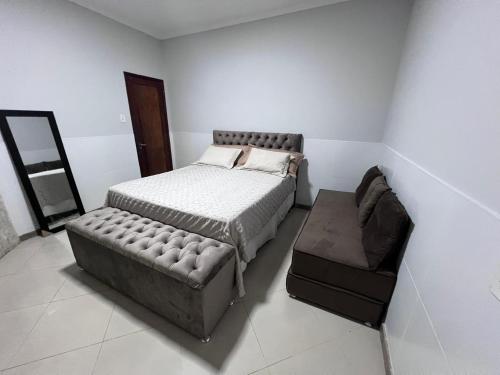 a bedroom with a bed and a couch at Recanto dos Maias in Aracaju