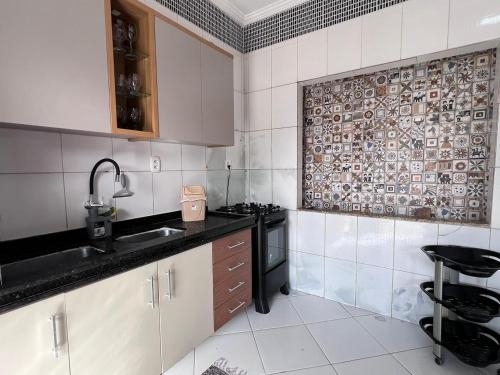 a kitchen with a sink and a stove at Recanto dos Maias in Aracaju