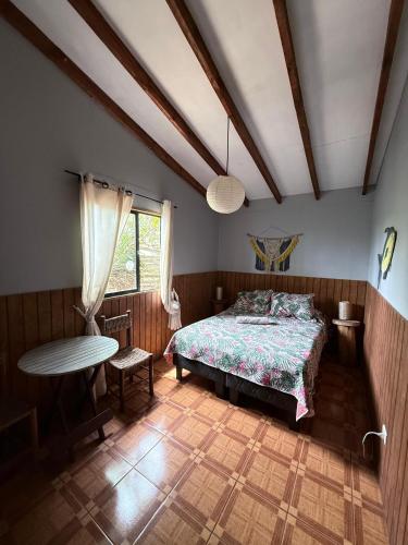 una camera da letto con un letto, un tavolo e una finestra di Hostal Vieroto a Hanga Roa