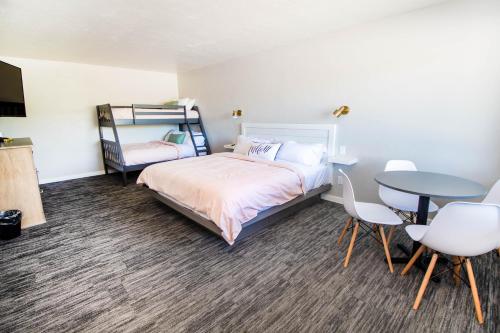 a bedroom with a bed and a table and chairs at The Painted Pelican in Luxemburg