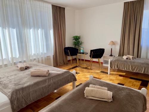 a hotel room with two beds and a table and chairs at Pension Francesco in Nuremberg