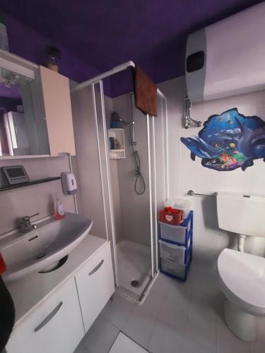 a bathroom with a toilet and a sink and a shower at casa RIVER in Scopello