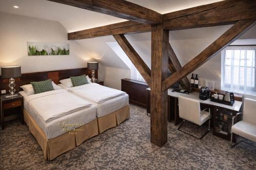 a bedroom with a large bed and a desk at Hotel Grand in Český Krumlov