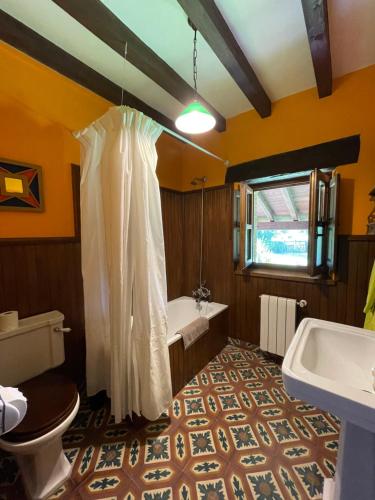 a bathroom with a tub and a toilet and a sink at Posada Rural Valoria in Valoria
