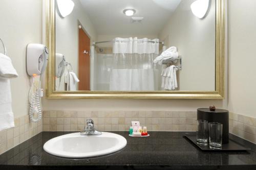 a bathroom with a sink and a mirror at Canalta Olds in Olds