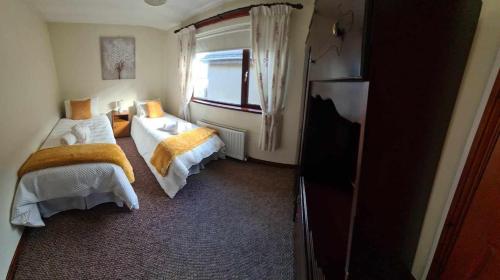 a hotel room with two beds and a television at Derry City Centre Kelly's Place et in Derry Londonderry