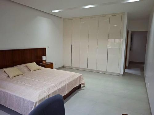 a bedroom with a large bed and a blue chair at Elegant 3-room apartment in Dakar