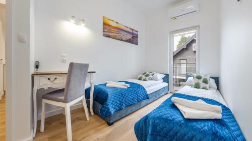 a bedroom with two beds and a desk and a chair at Dom Horizon Park 3A in Dziwnówek