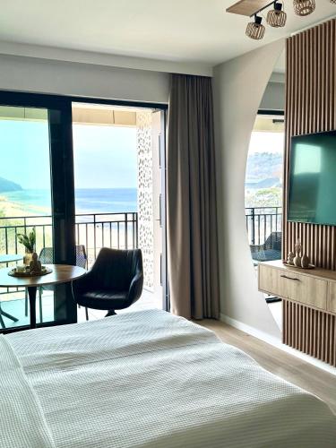 a bedroom with a bed and a television and a table at Baltic Infinity Suite 413 - SPA & Pool Access in Międzyzdroje