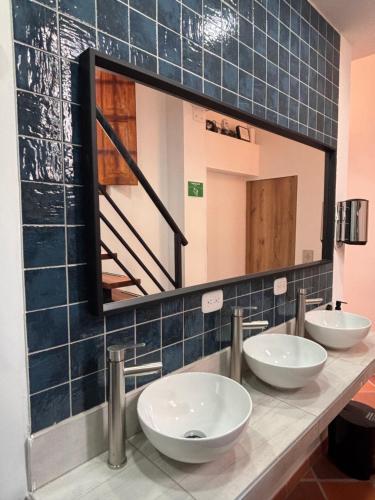 a bathroom with three sinks and a mirror at Hostal Boutique Loto de Belén in Bogotá