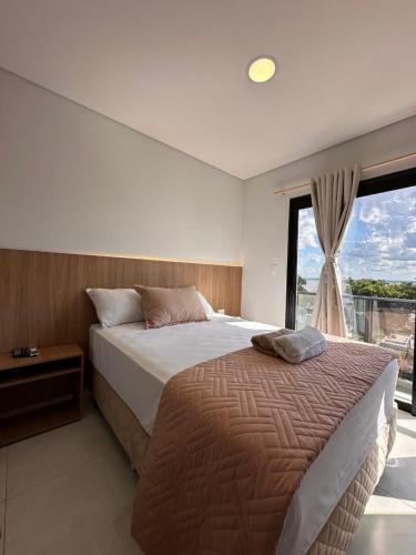 a bedroom with a large bed and a window at Paraná Beach Apart Hotel in Encarnación