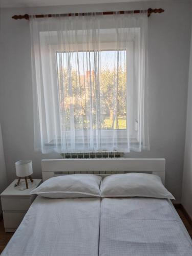a bedroom with a white bed and a window at Apartma S&M in Koper