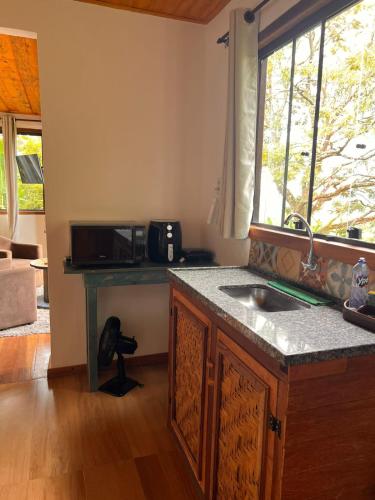 a kitchen with a sink and a counter top at Chalé da Mata Lavras Novas in Lavras Novas