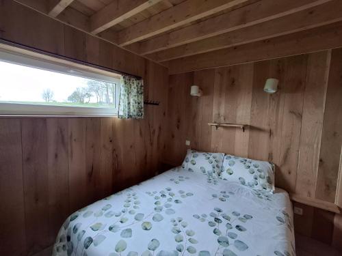 a bed in a small room with a window at Chalet charme et bien-être Jacuzzi et nature près de Durbuy in Durbuy