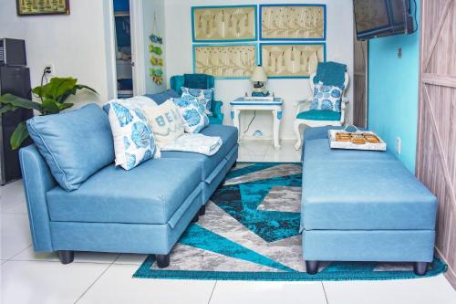 a blue couch and two chairs in a living room at Miami Boho Beach Place in Hialeah