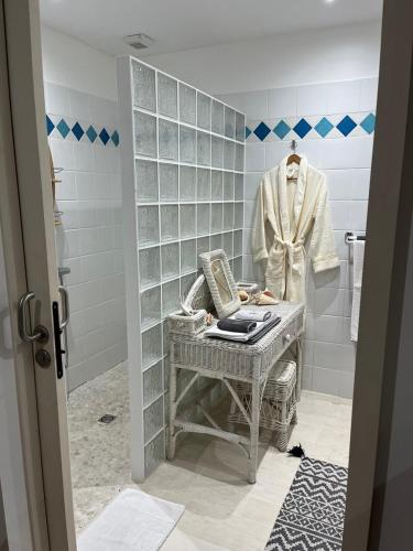a bathroom with a suit on a mannequin and a sink at Habitation Tara in Capesterre-Belle-Eau