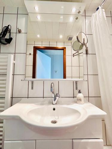 a bathroom with a sink and a mirror at Ferienwohnung Westerlicht - Apartment am Leuchtturm - De Torenhoeve in Nieuw-Haamstede