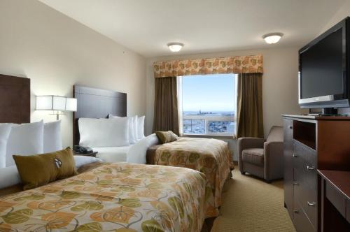 a hotel room with two beds and a television at Canalta Olds in Olds