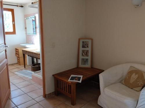 a living room with a chair and a coffee table at Maison du vieux chêne in Grimaud