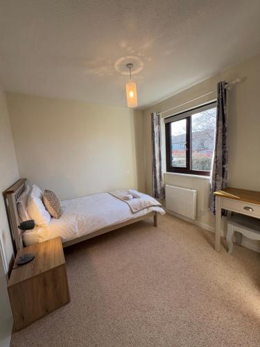a bedroom with a bed and a desk and a window at Arcadia - Kirkwall in Orkney