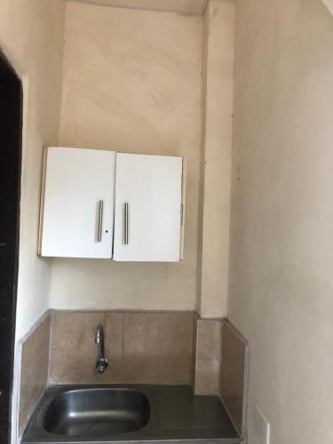 a kitchen with a sink and white cabinets at Habitación orégano in Santa Elena