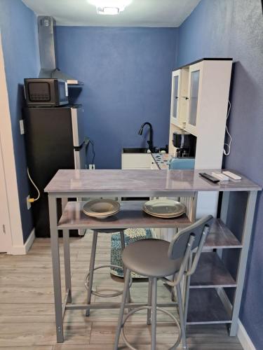 a table with two chairs in a room with a blue wall at Small's Cozy Rest 9 Efficiency in South Bimini