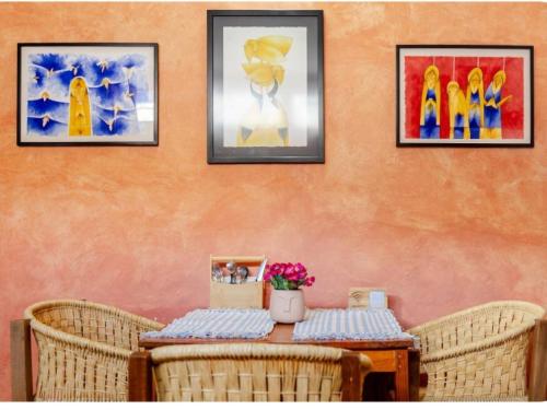 a table with wicker chairs and a table with flowers on it at Casa Mixteca Santo Domingo Oaxaca in Oaxaca City