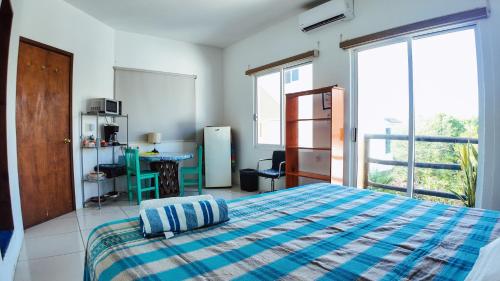 a bedroom with a bed with a blue and white blanket at BRISAMAR GUESTHOUSE in Puerto Escondido