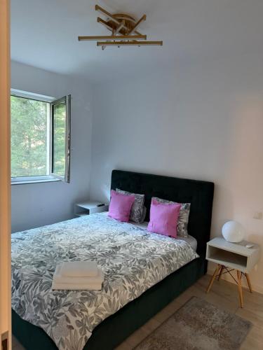a bedroom with a large bed with pink pillows at Pipera Garden Apartment in Voluntari