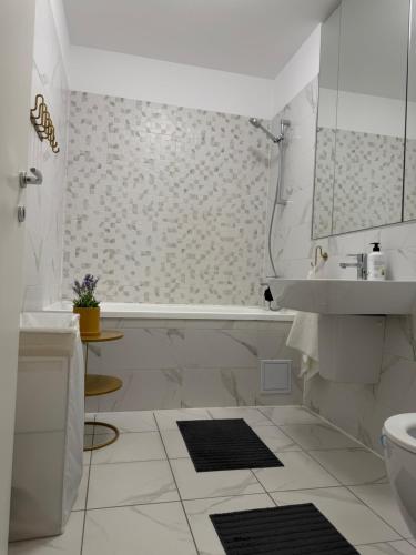 a white bathroom with a tub and a sink at Pipera Garden Apartment in Voluntari