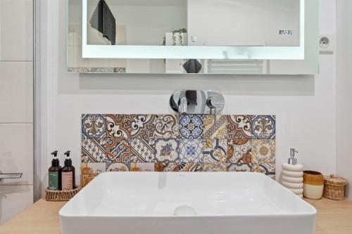a kitchen with a white sink and a mirror at Haban Haus in Bratislava