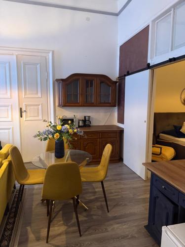 a kitchen with a table and yellow chairs and a room at CpB3 in Bratislava