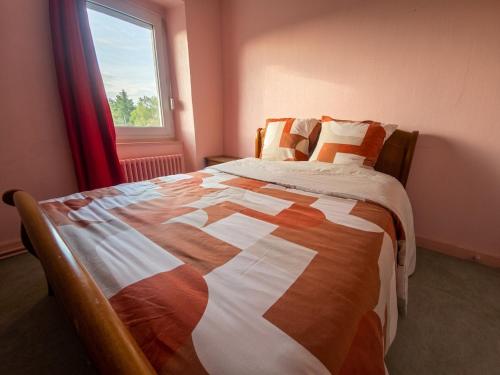 a bedroom with a large bed with a window at Chez ValJean in Châlus
