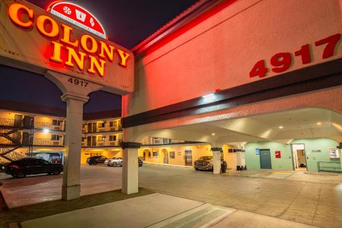 a sign for a town inn with cars parked in a parking lot at Colony Inn - North Hollywood - Hotel Near Universal Studios in North Hollywood