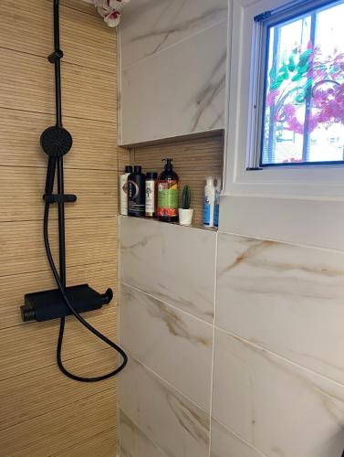 a bathroom with a shower with a hose on the wall at Casa de Elena Marousi in Athens