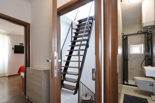 a spiral staircase in a bathroom next to a toilet at Rooms & Apartments 72 in Zadar