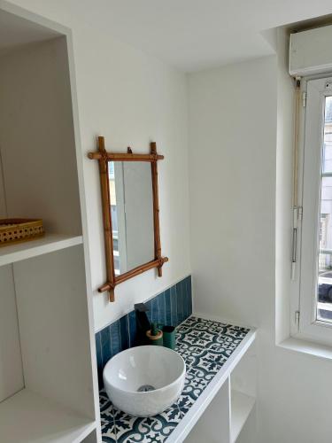 a bathroom with a white sink and a mirror at Appartements Lambotte in LʼAigle