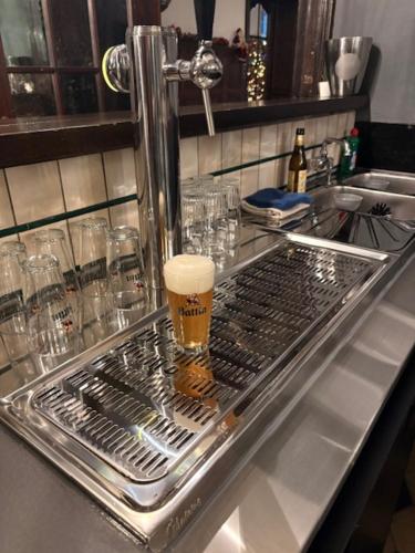 a metal sink with a cup of beer on it at Le Tri Renard Spa in Spa