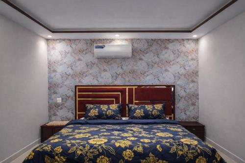 a bedroom with a bed with a blue and yellow bedspread at Private 2BD Apartment Opposite Dha Phase 8 in Lahore