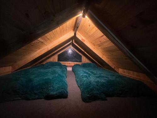 ein Zimmer mit zwei grünen Kissen auf dem Dachboden in der Unterkunft tiny house DyL in Puerto Montt