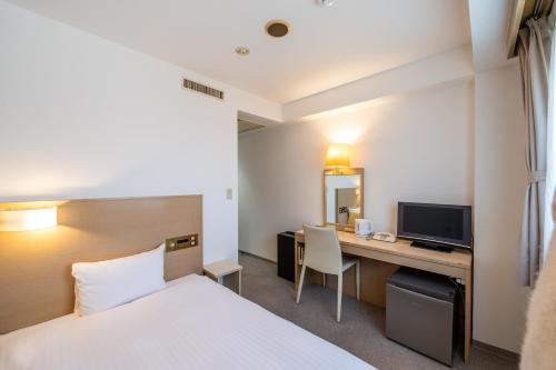 a hotel room with a bed and a desk at 大和パークホテル in Taiwa