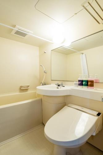 a bathroom with a toilet and a sink and a mirror at 大和パークホテル in Taiwa