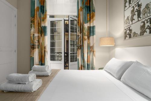 a bedroom with a white bed with towels on it at MARITXU'S HOME in San Sebastián